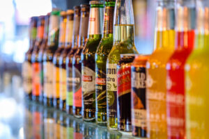 Various beer bottles and labels lined up down a counter