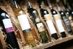 A row of wine bottles with labels of various sizes and designs