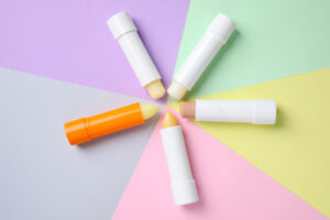 Five different lip balm tubes arranged in a circle in various colors